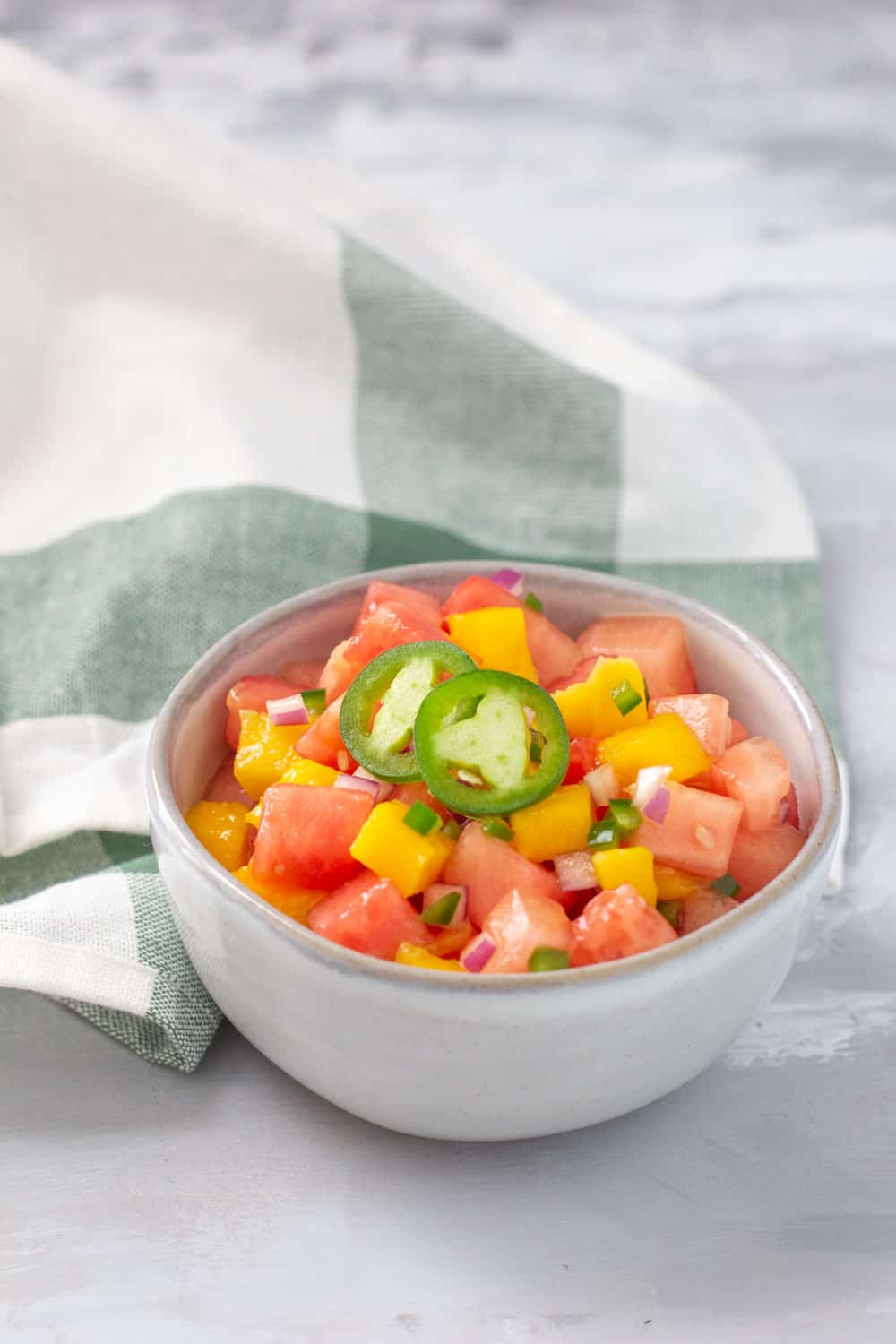 bowl of fruit salsa on a green kitchen towel