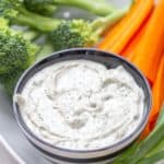 ranch dip in a striped bowl with vegetables