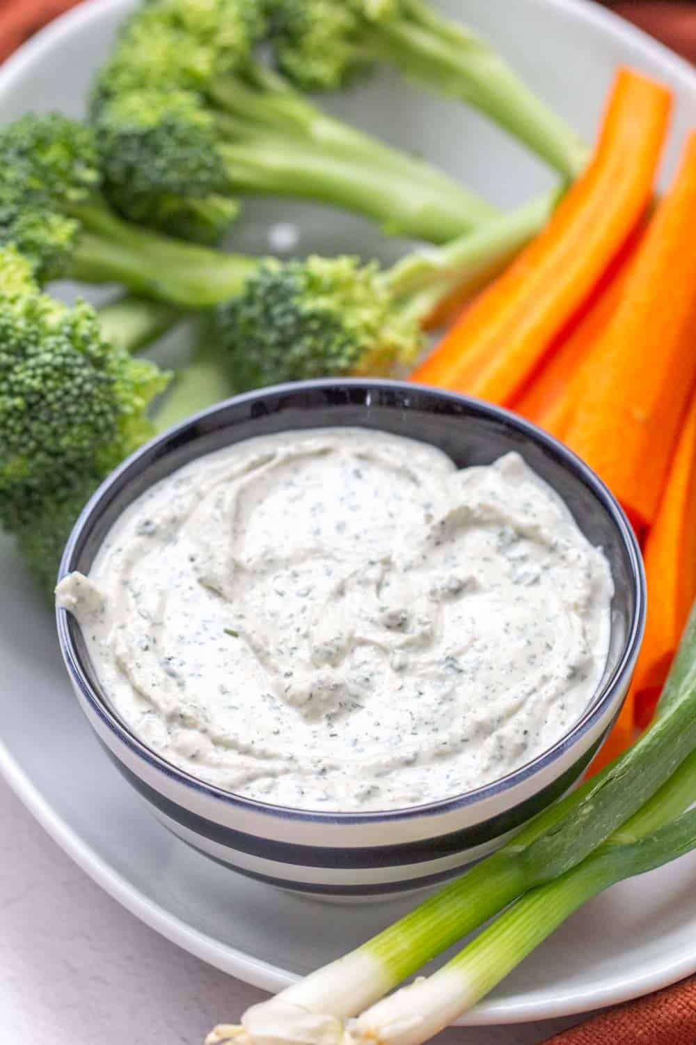 ranch dip in a striped bowl with vegetables