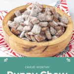 A wooden bowl brimming with delicious puppy chow sits atop a red and white patterned napkin. Below, a green banner proudly announces "Crave-Worthy Puppy Chow," while "HappySnackcidents.com" signs off with style.