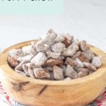 A wooden bowl brimming with powdered sugar-coated puppy chow rests on a vibrant red patterned cloth. The text proclaims, "Easy Recipe Puppy Chow.