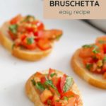 Tasty slices of bread adorned with diced tomatoes and herbs invite you to try our "Tomato Bruschetta easy recipe." Don't miss the chance to explore this savory delight—check out the website link below for more!.