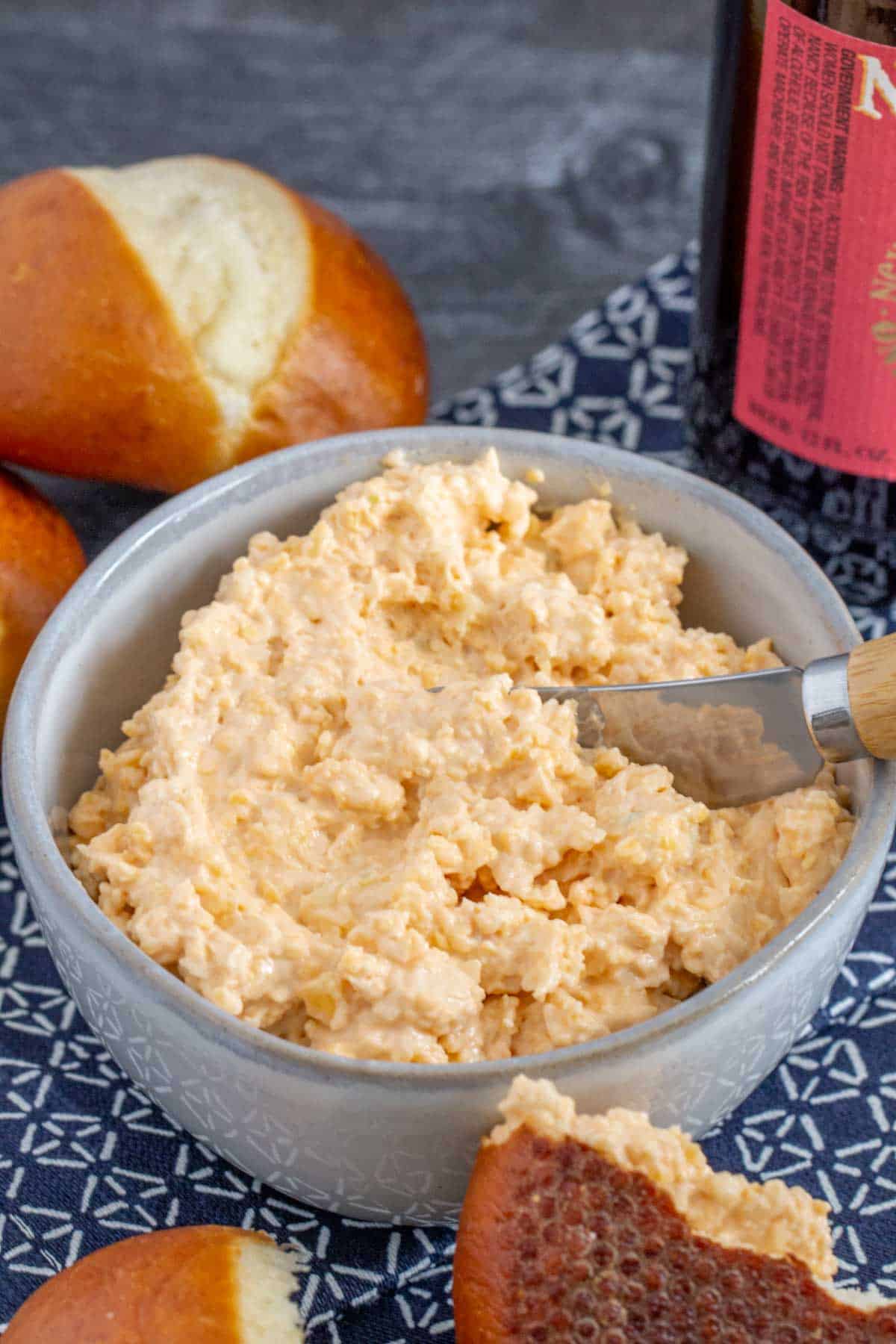 gray bowl of beer cheese dip with spreader