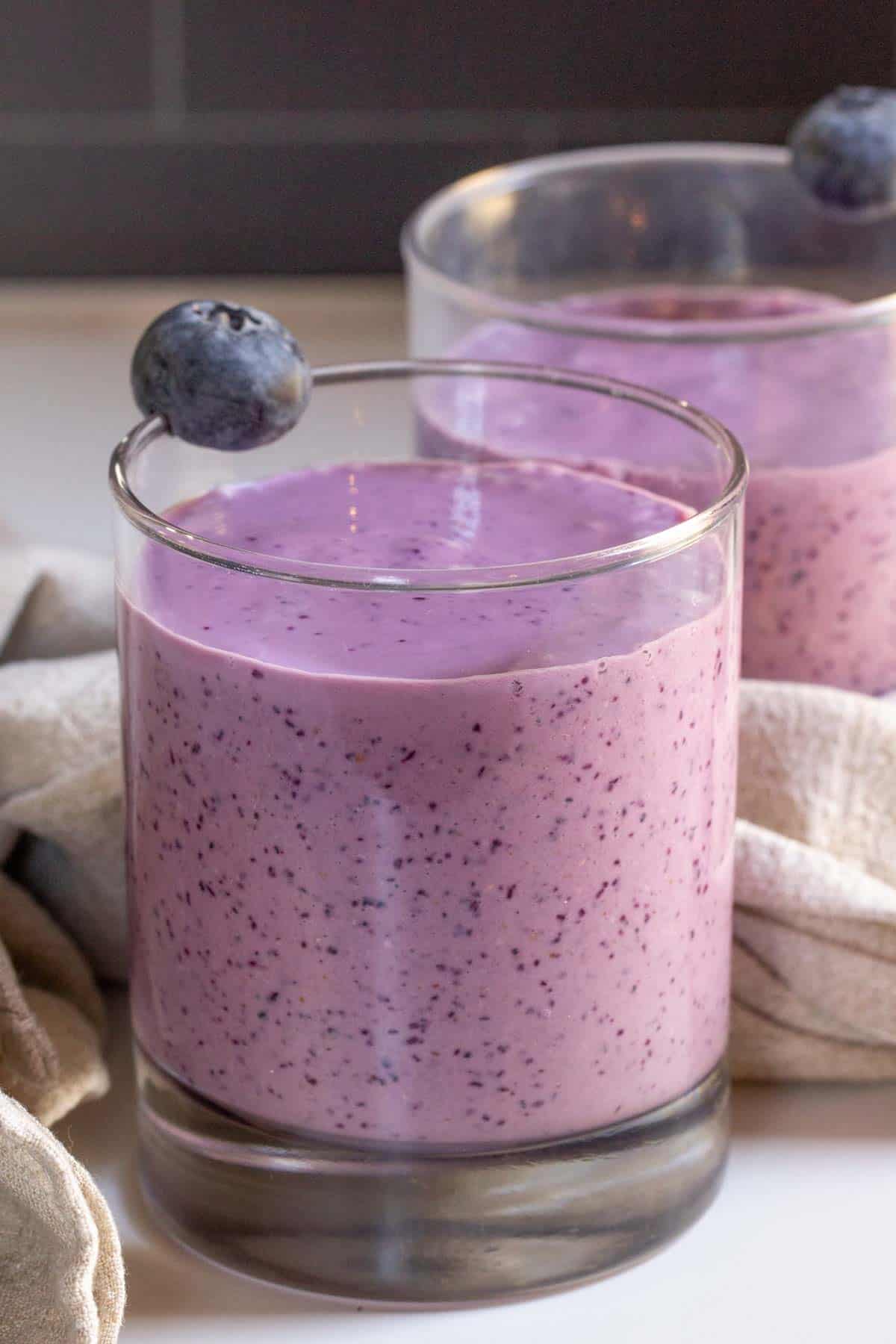 glass filled with blueberry oatmeal smoothie