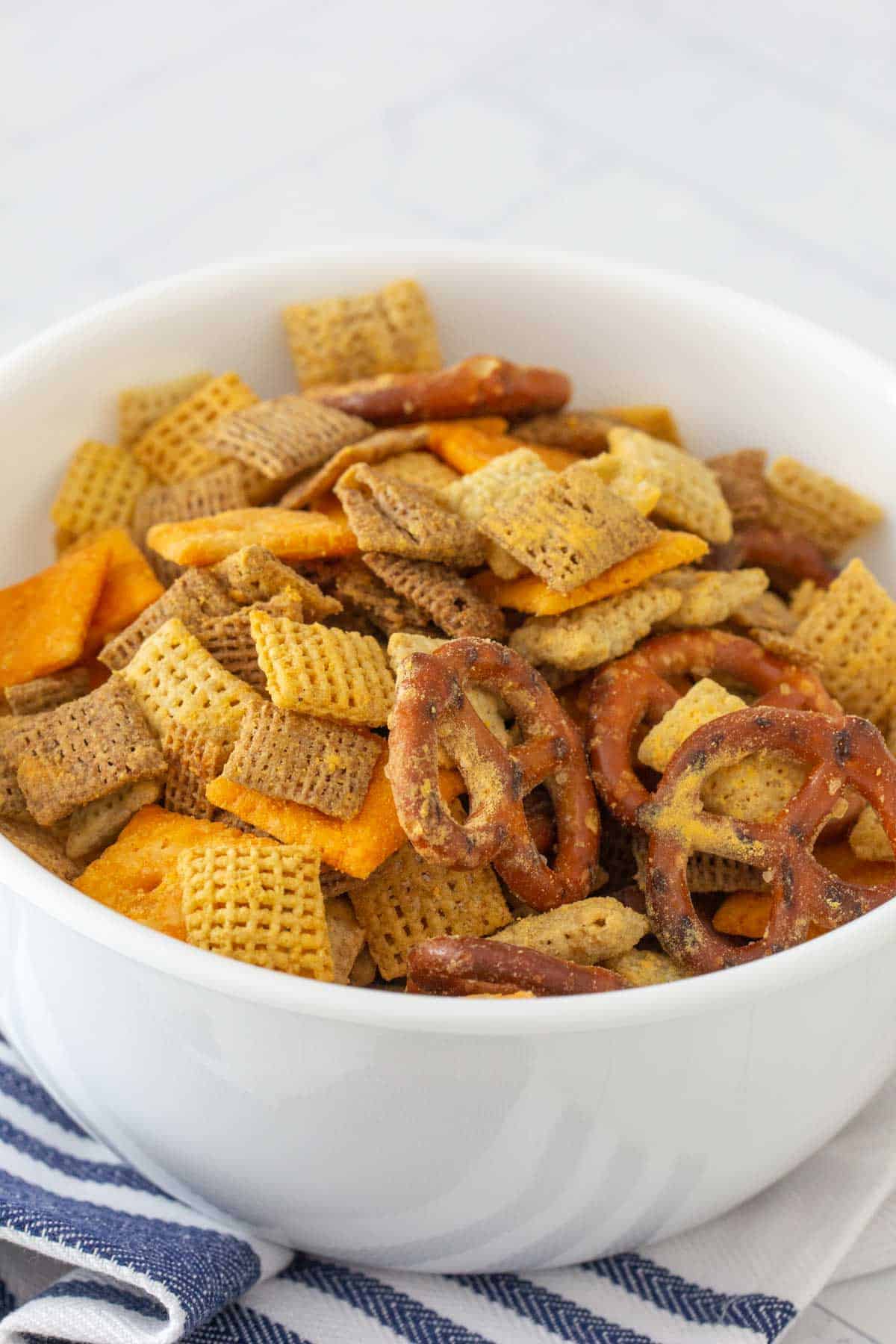 close up of cheddar chex mix in white bowl
