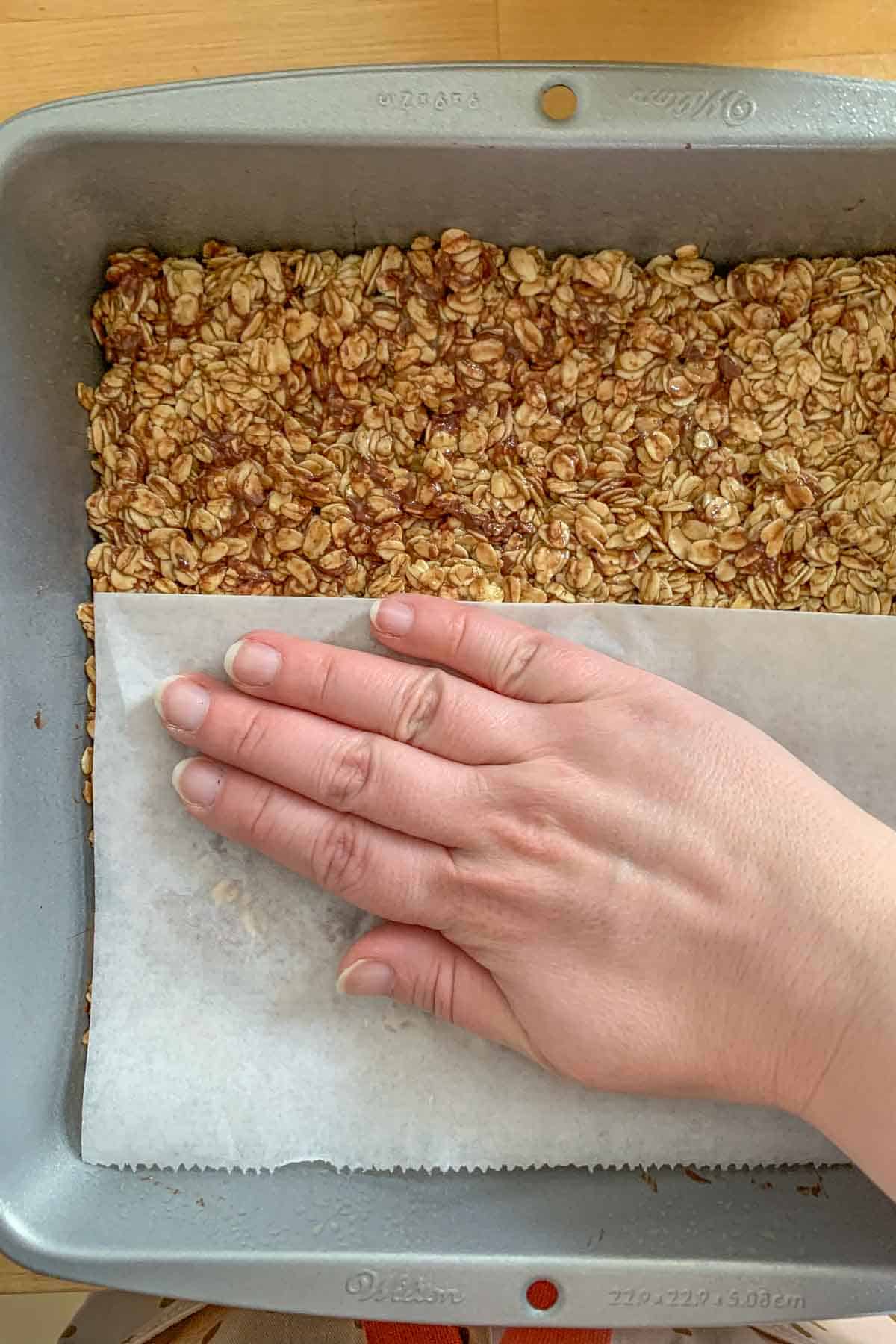 pressing granola bar mixture into pan