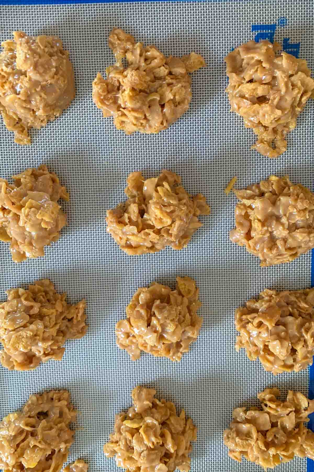 cornflake cookies setting on a silicone liner