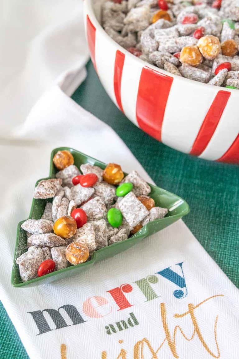 Reindeer chow in a tree-shaped bowl on a Christmas kitchen towel.