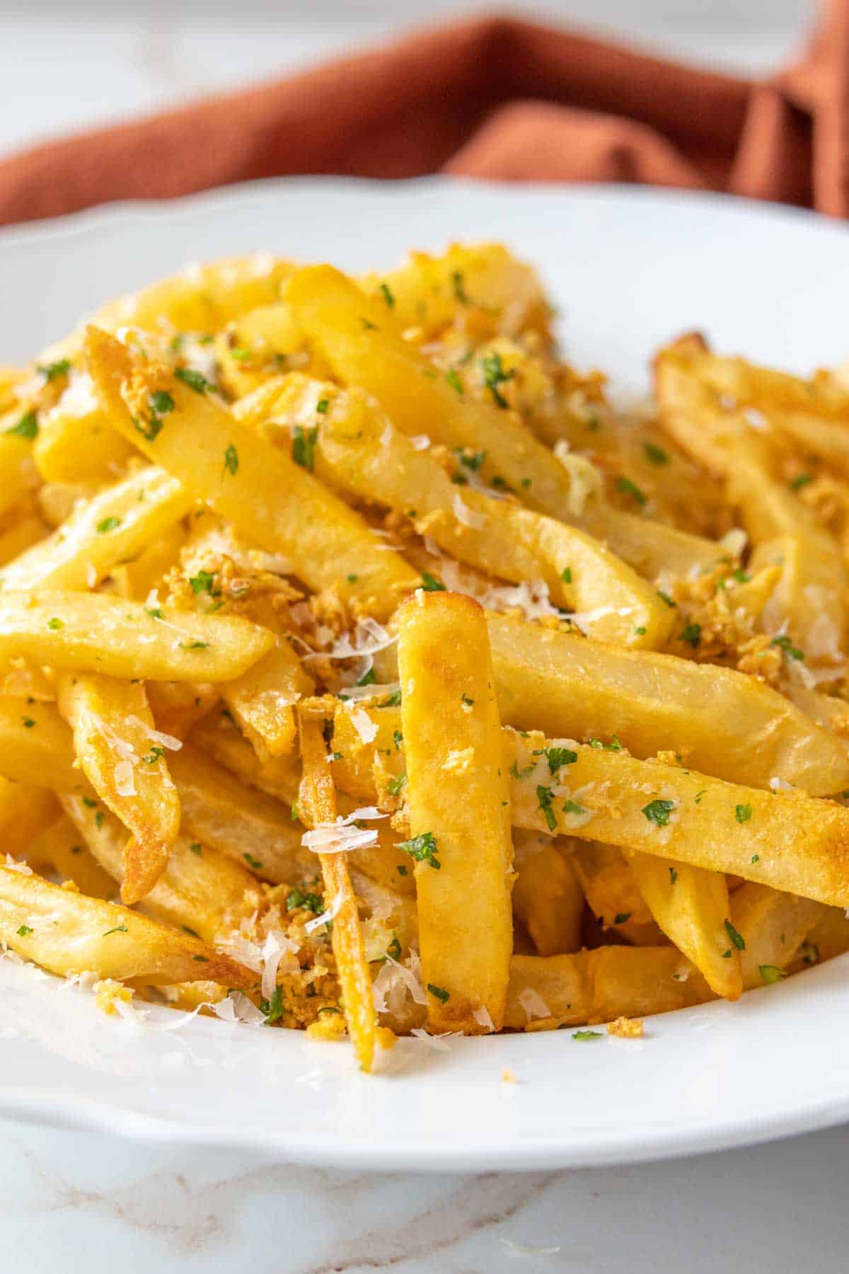 White bowl filled with garlic fries.