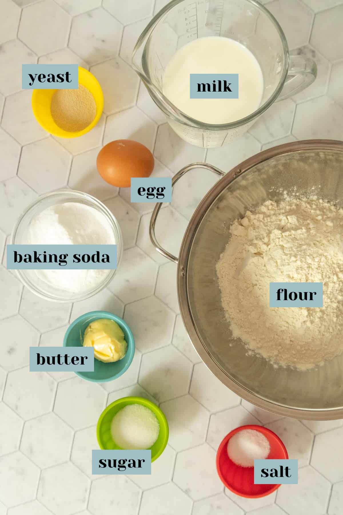 Ingredients for soft pretzels on a tile surface with labels.