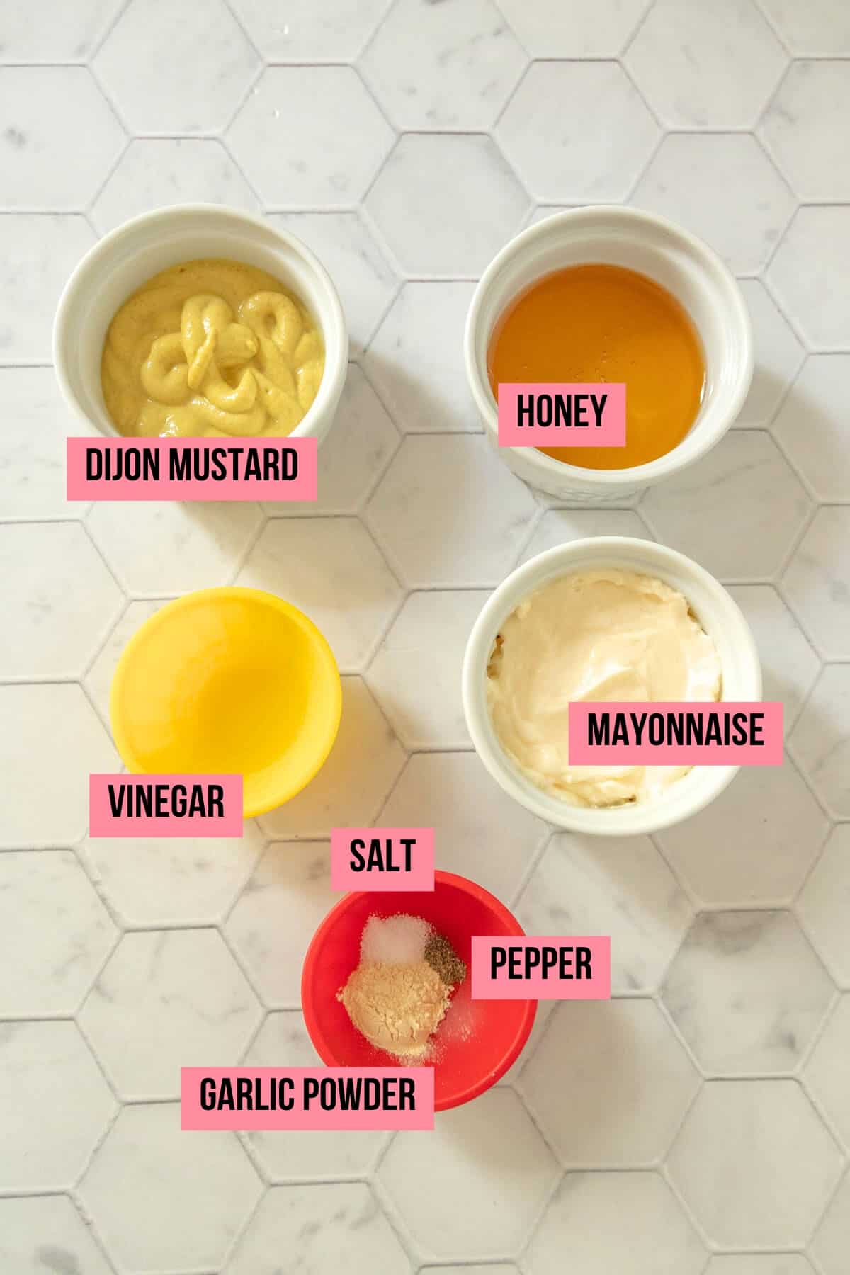 Ingredients for honey mustard sauce on a tile surface with labels.
