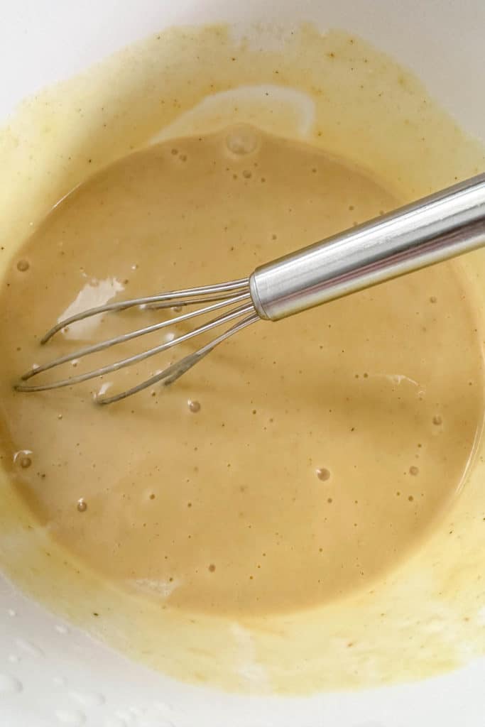 Honey mustard sauce in a white bowl.