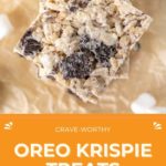 Top view of Oreo Rice Krispie Treats stacked on parchment paper, highlighting the delicious blend of marshmallow, rice cereal, and Oreo pieces. Text reads "Crave-Worthy Oreo Rice Krispie Treats" with a website link.