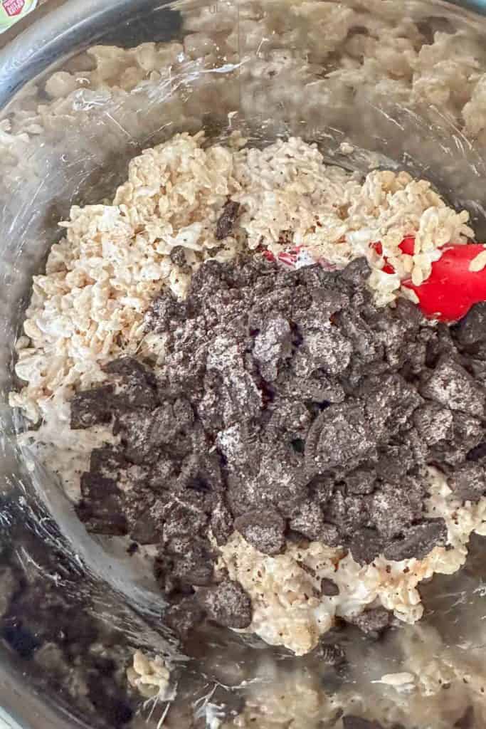 Mixing Oreo pieces into rice krispie treat mixture.