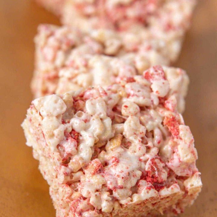 Line of strawberry rice krispie treats on a wooden tray.
