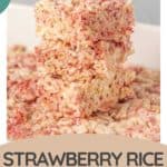 Three strawberry rice krispie treats stacked on top of each other, with more treats scattered around on a white surface. Text overlay reads "Strawberry Rice Krispie Treats.