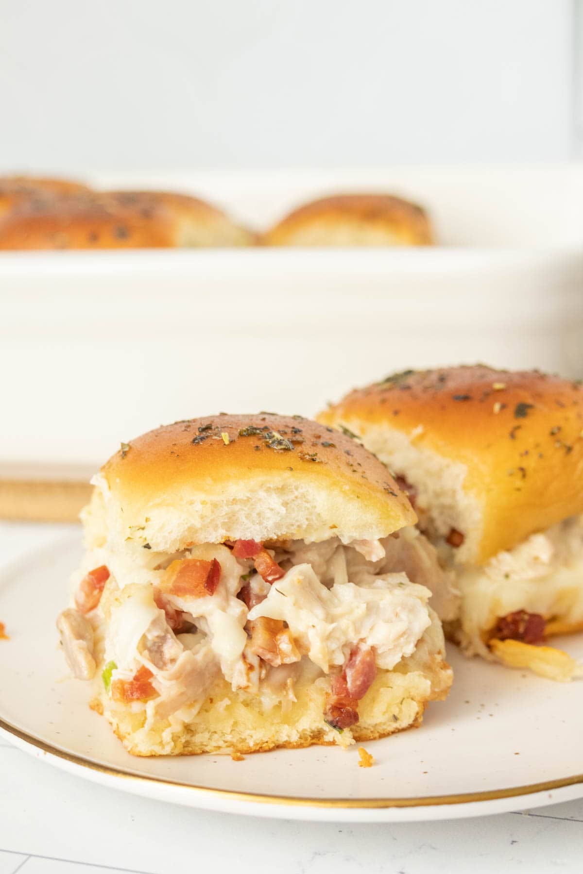 Chicken and bacon sliders on a plate.