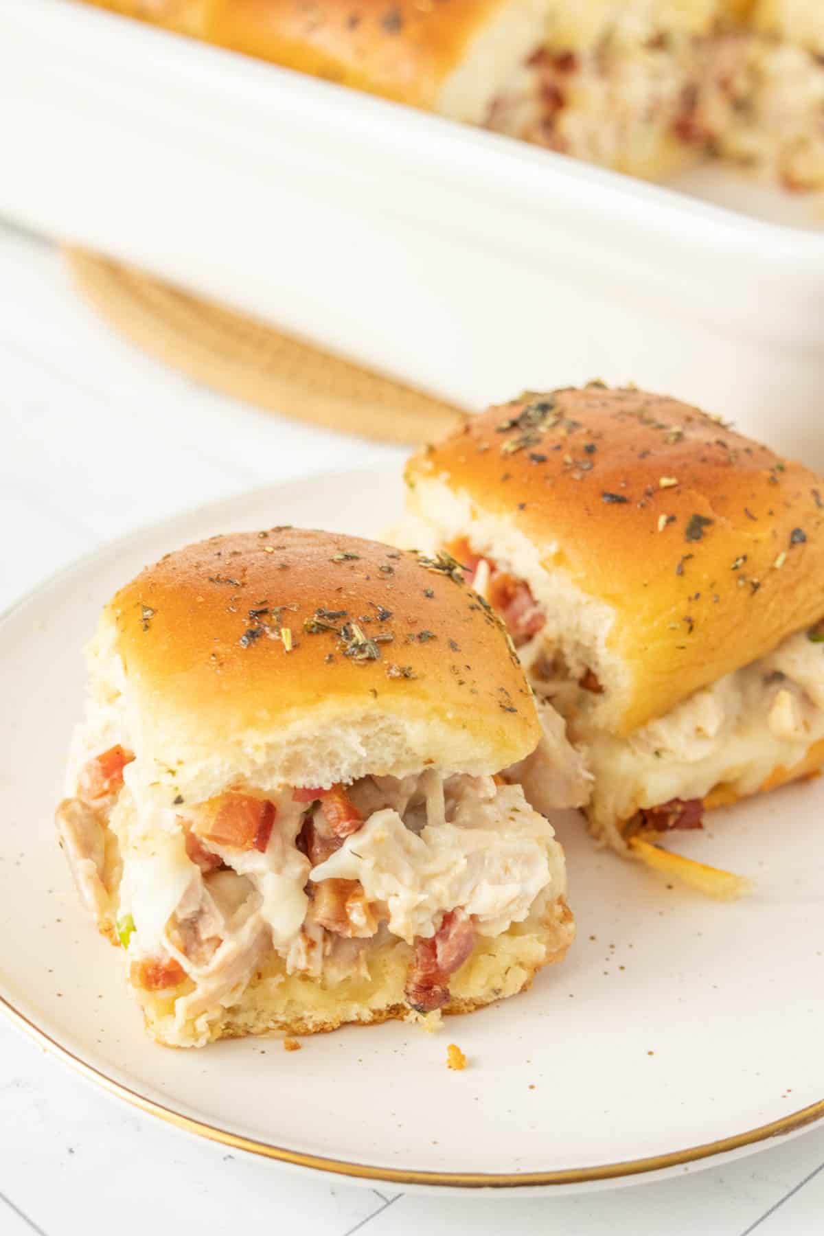 Chicken sliders on a white plate.