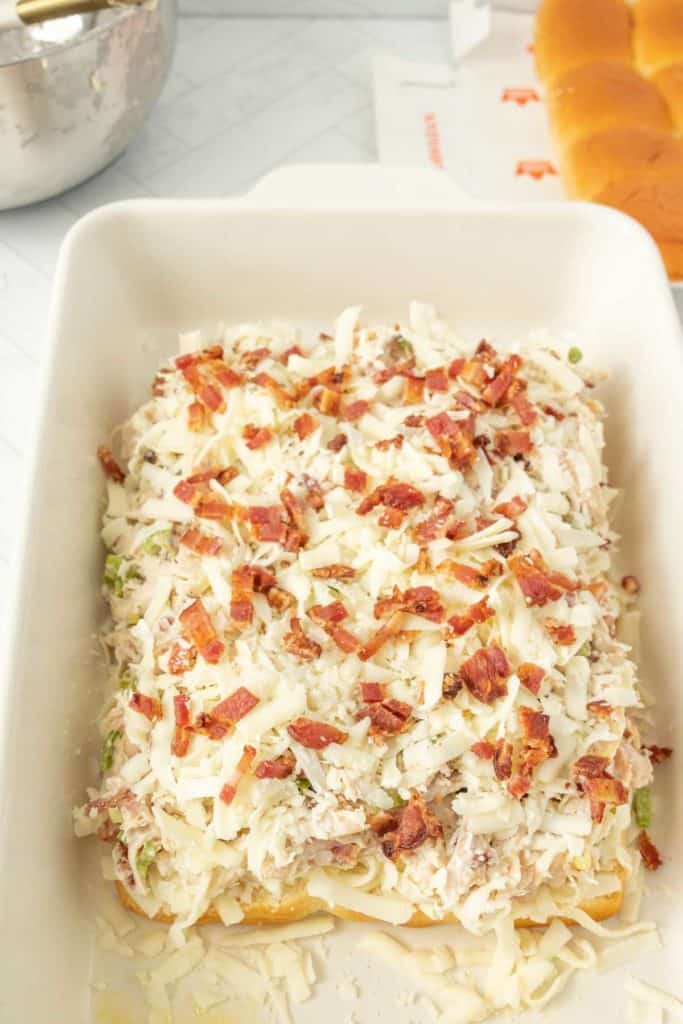 A casserole dish with bacon and cheese on it.