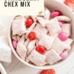 Bowl of strawberry-flavored Chex mix with red and pink candies and dried strawberries, alongside the text "Easy Recipe: Strawberry Chex Mix.